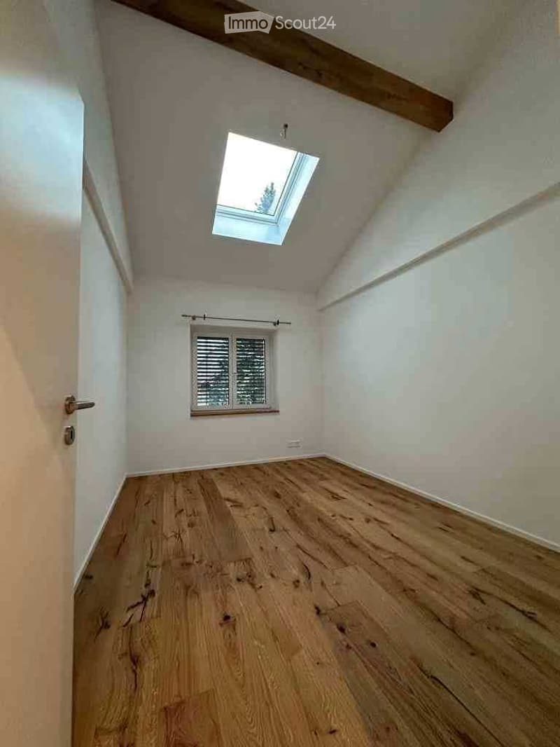 Empty room with wooden flooring, white walls, and a skylight window. No furniture or equipment present.