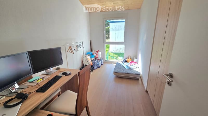 desk with computer, chair, small bed, window, wooden floor, wooden ceiling
