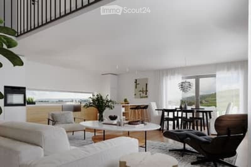 Modern, open-concept living and dining area with white walls, large windows, a grey sofa, coffee table, dining table with bar stools, and a potted plant.