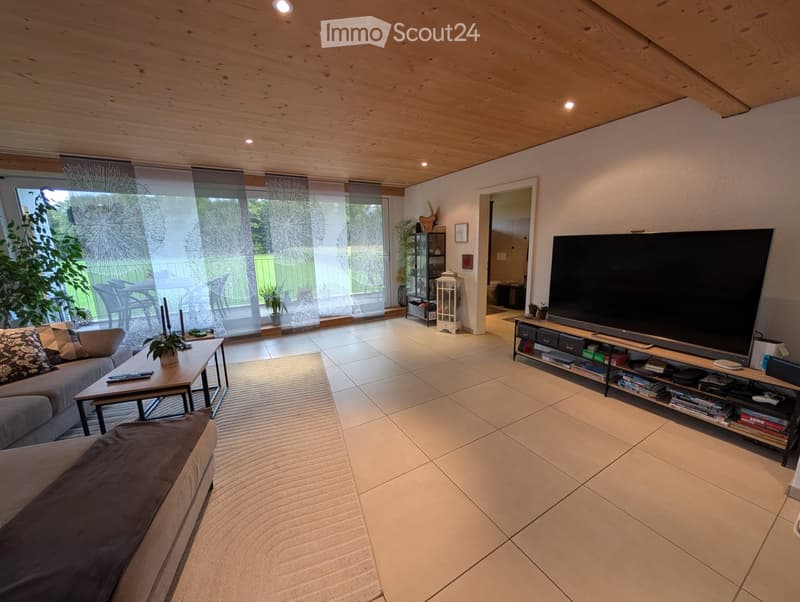 open layout, tile flooring, windows, large couch, TV stand, entertainment center, fireplace