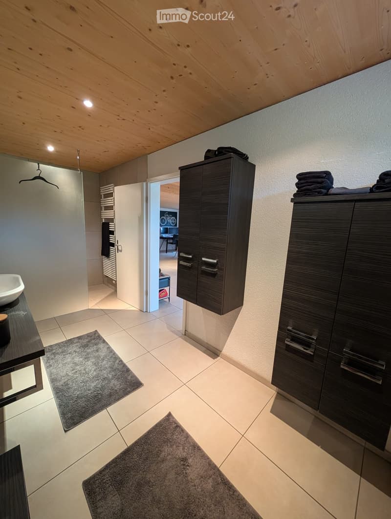 washroom with sink, shower, wooden ceiling, shelves, cabinets, rugs, black hanging coat rack