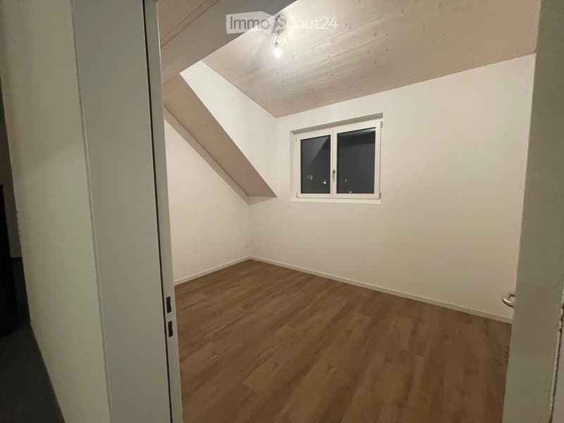 Empty room with wooden flooring, white walls, and a skylight window. No furniture or equipment present.