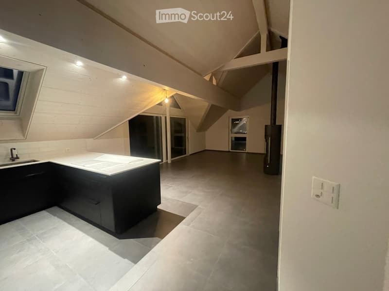 Modern kitchen with white tiled floor, black cabinetry, and a white countertop. Features a sink, built-in cabinets, and large windows allowing natural light.
