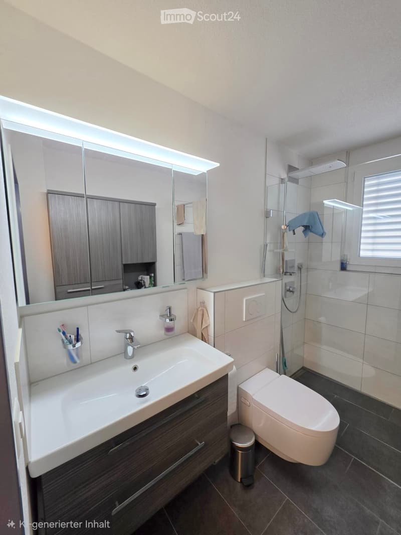 Modern bathroom with a large mirror, sink, toilet, and glass-enclosed shower. Features include a wooden cabinet, towel rack, and a small window.