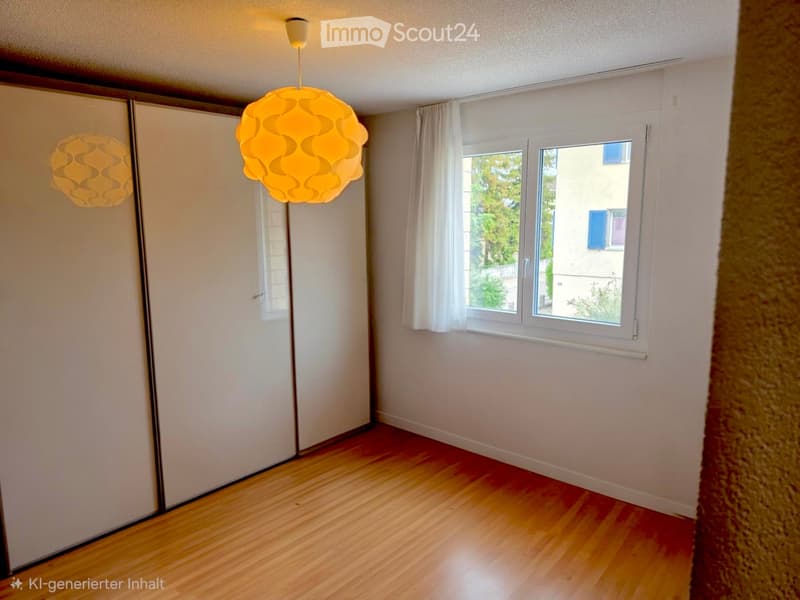 Empty room with wooden flooring, white walls, large windows with white curtains, and modern pendant lights.
