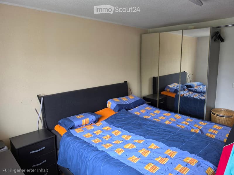 Bedroom with a double bed, blue and orange bedding, nightstand, wardrobe, and mirror.