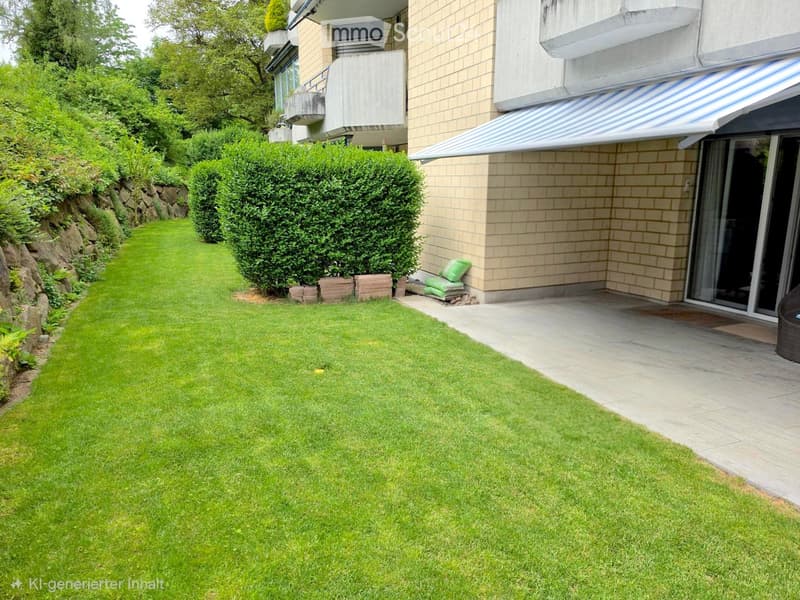Well-maintained lawn with trimmed hedges, a stone retaining wall, and a modern building with a covered entrance and balcony.