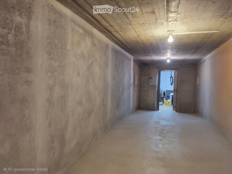 Empty concrete corridor with exposed ceiling beams, single light fixture, and two open doors at the end.