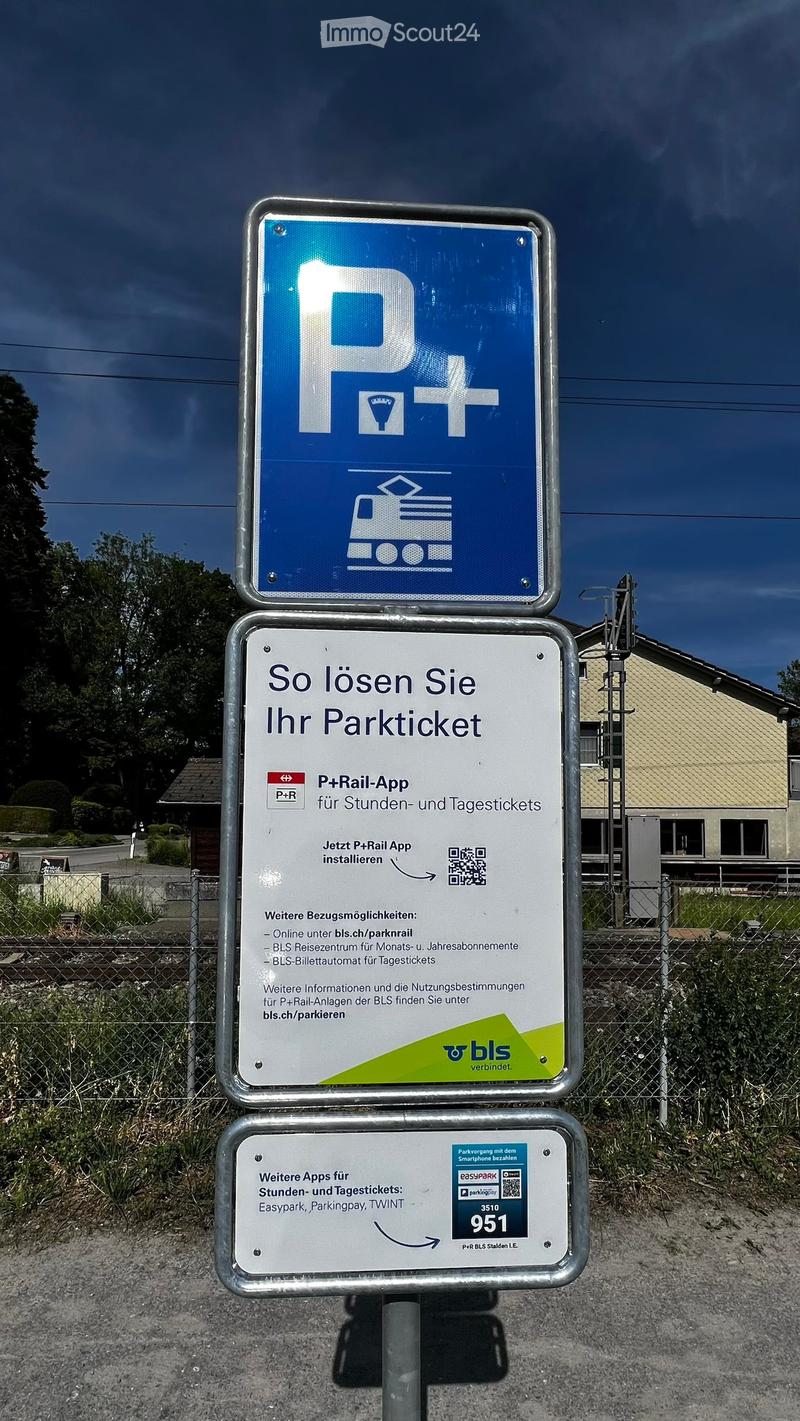Parking sign displaying instructions for solving parking tickets using the P+Rail app, with additional information and QR codes for other parking apps.