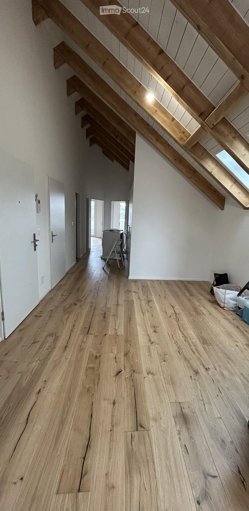 Empty room with wooden flooring, white walls, and a staircase leading upwards. No furniture or equipment visible.