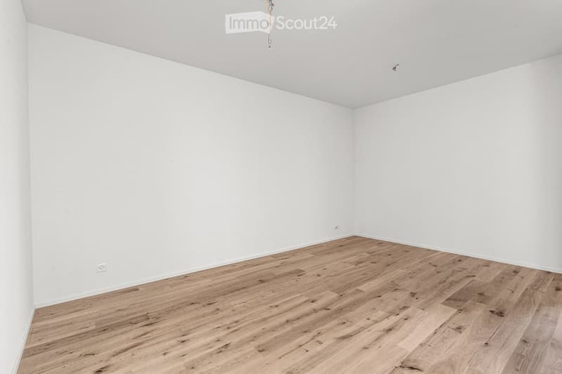 Empty room with white walls and light wooden flooring, no furniture or equipment present.