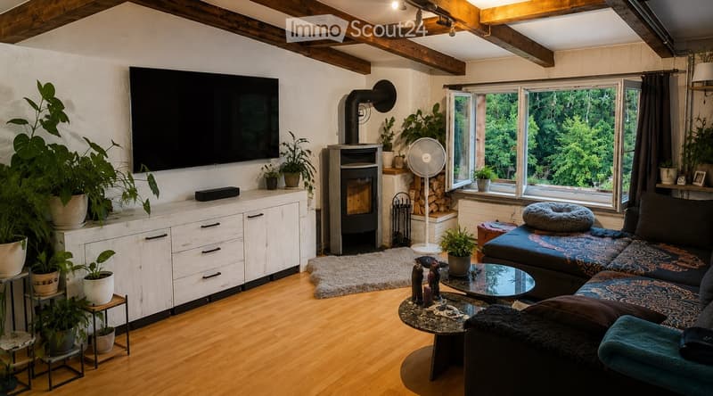 Cozy living room with exposed wooden beams, a fireplace, a large TV, a sofa, coffee table, and several potted plants. Large windows offer a view of greenery outside.
