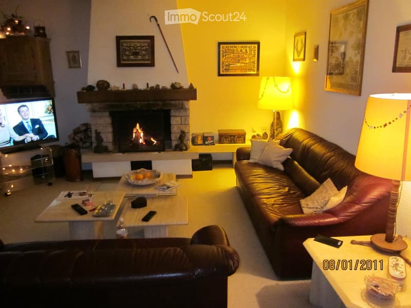 living room with fireplace, two couches, center table, lamps, TV