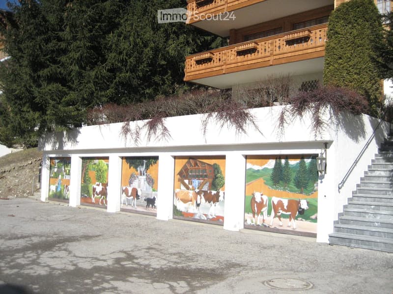 Garage wall with artistic paintings, wooden steps, wooden balcony railings, shrubs