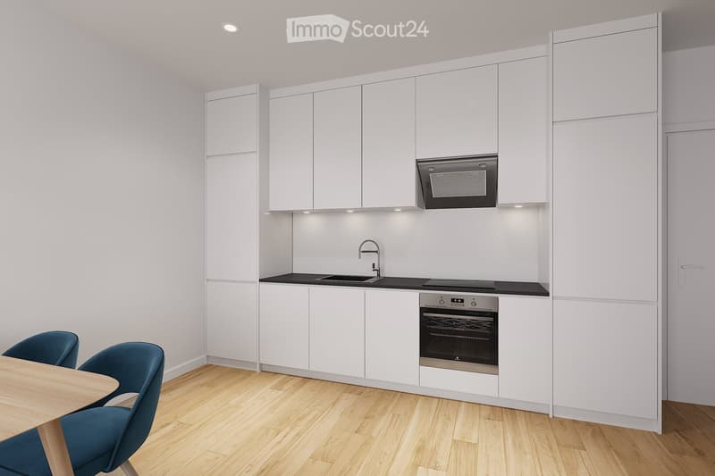 Modern kitchen with white cabinets, black countertops, stainless steel appliances, and a wooden dining table with blue chairs.