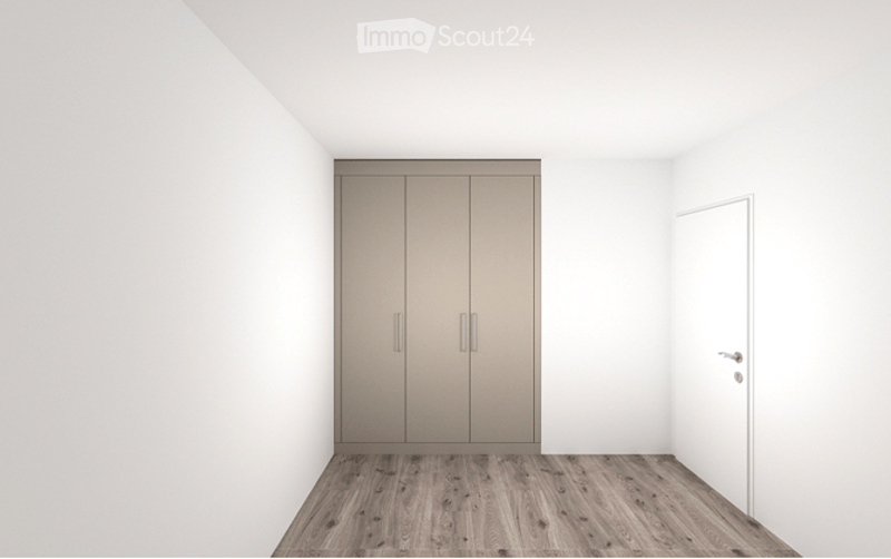 Empty room with light wooden flooring, white walls, and a built-in wardrobe with double doors.