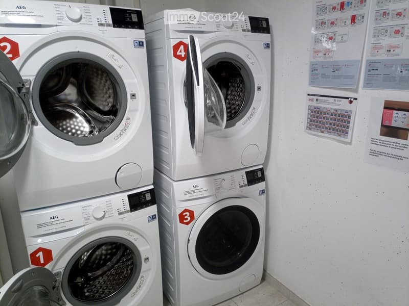 Stack of 4 washing machines, all white, AEG brand, red numbers on front