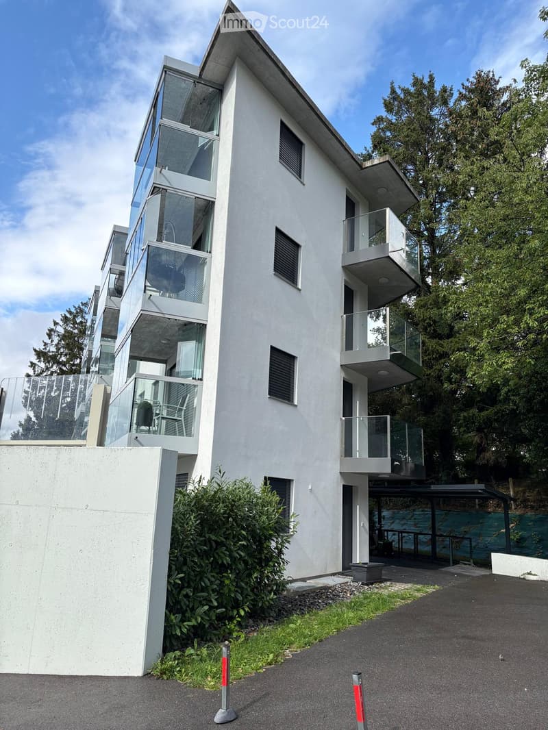 Contemporary apartment building with glass balconies and white exterior