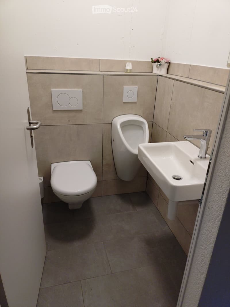 Compact bathroom with a toilet, urinal, and a washbasin.
