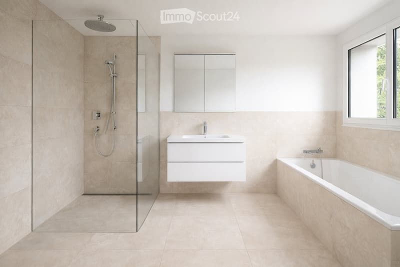 Modern bathroom with a bathtub, sink, mirror, and glass-enclosed shower area. Light beige tiles and a large window provide natural light.