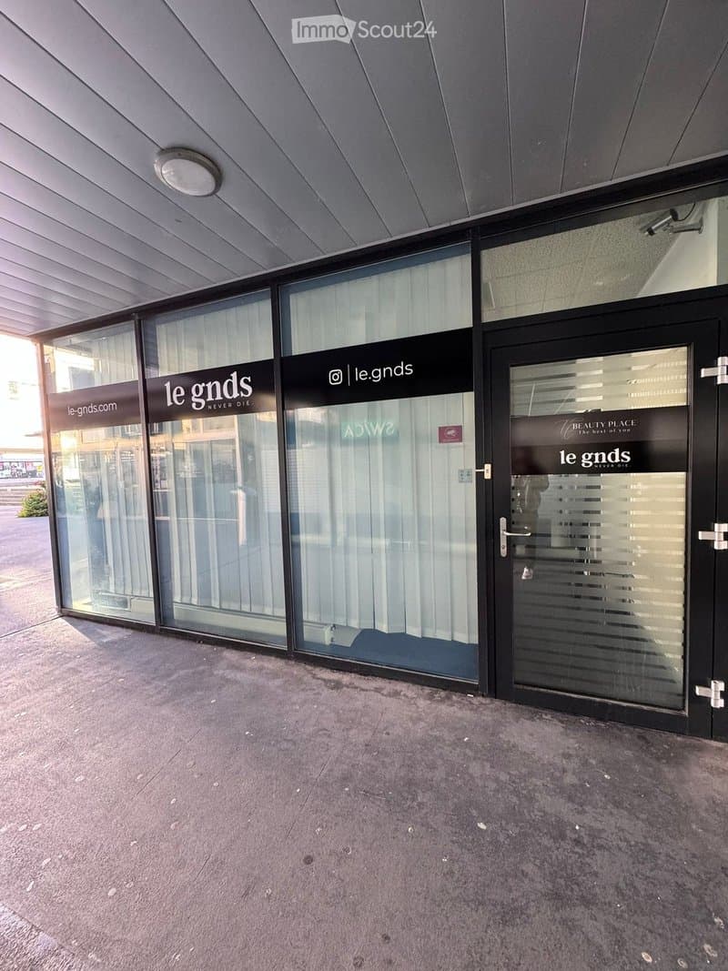 Modern storefront with large glass windows and a black entrance door, featuring signage for 'le gnds' and 'Beauty Place.'