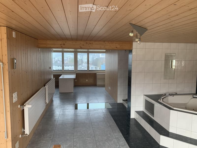 Modern bathroom with wooden ceiling, tiled walls, sink, bathtub, mirror, radiator, and cabinet.