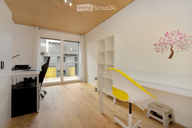 Modern office space with a desk, chair, and a bookshelf. A lamp is on the desk, and a step stool is nearby.