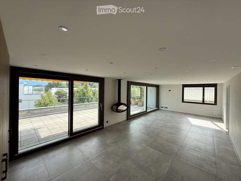 Empty room with tiled floor, large sliding glass doors leading to a balcony, and recessed ceiling lights.