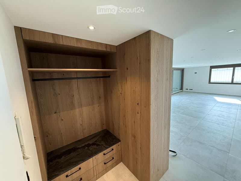 Empty room with wooden built-in closet, marble countertop, and tiled floor. No furniture or personal items present.