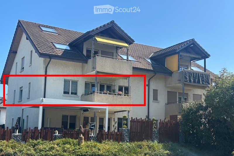 Two-story house with a tiled roof, multiple windows, and a balcony on the upper floor.