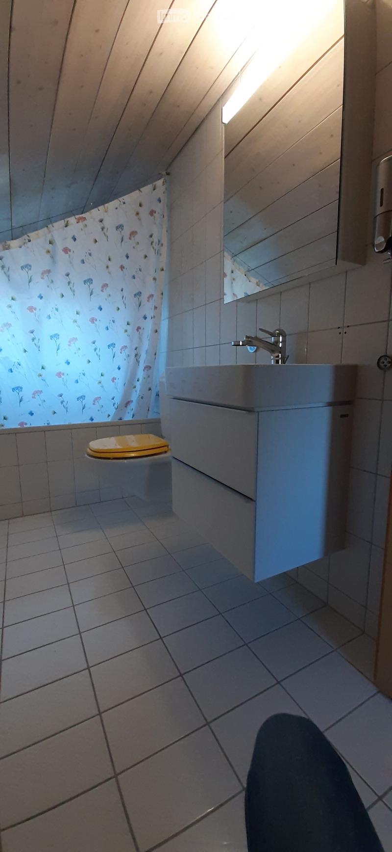Bathroom with shower, white tiled walls, sink with faucet, mirror, yellow toilet, and shower curtain