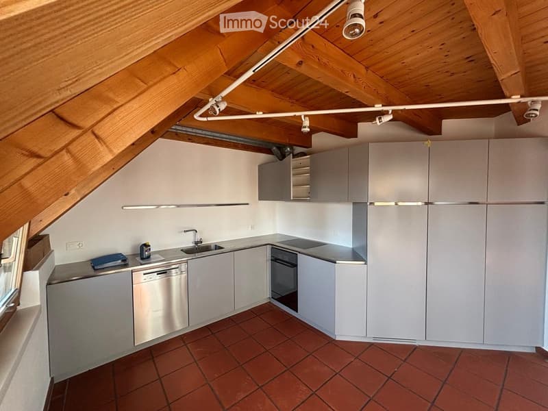 Modern kitchen with white cabinets, stainless steel appliances, and a tiled floor.