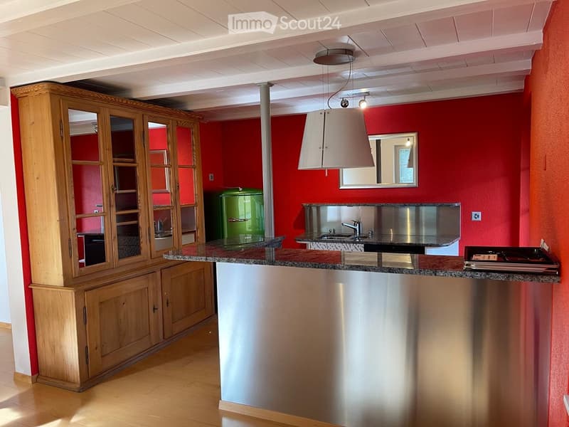 Modern kitchen with wooden cabinetry, granite countertop, stainless steel sink, and a pendant light fixture.