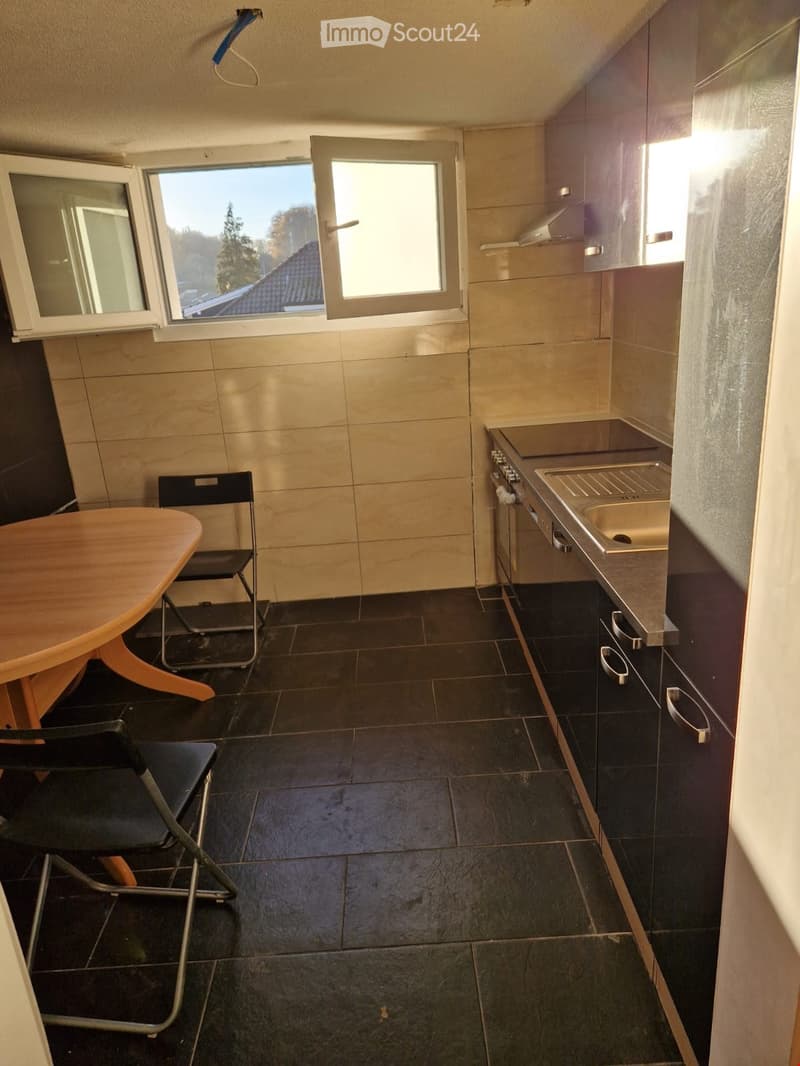 small kitchen with a table, chairs, and a sink