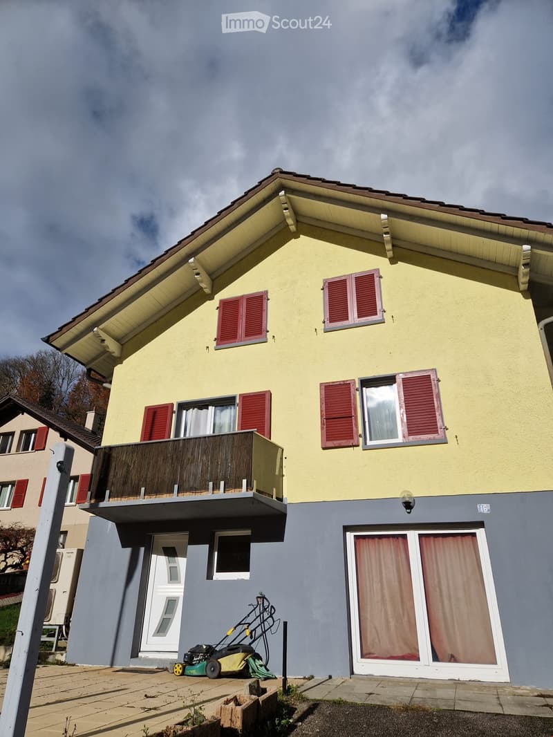 2 story house, yellow and gray, red shutters, balcony, garage, lawn mower