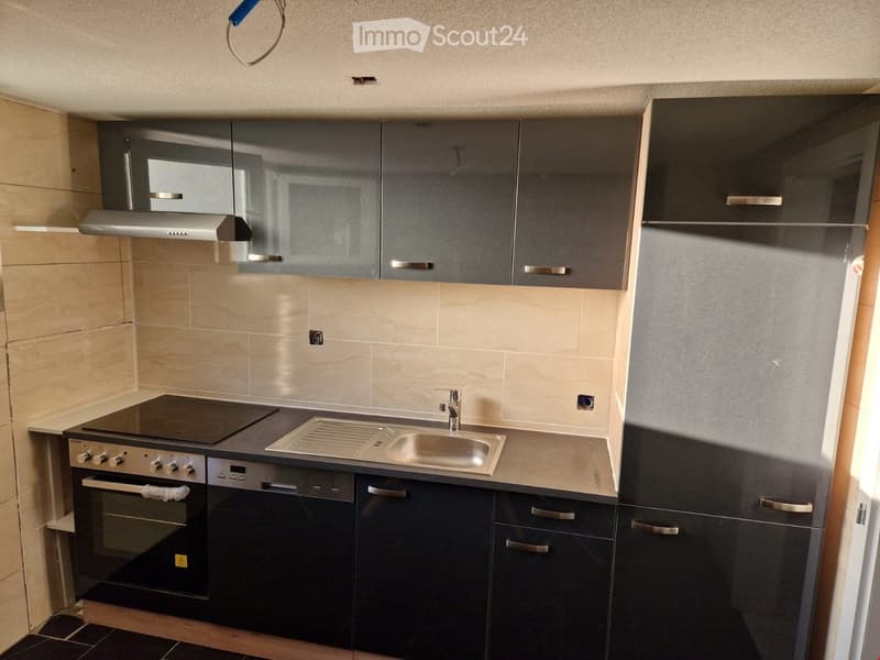 modern kitchen with black cabinets, stainless steel countertop, gas stove, oven, sink, and dishwasher
