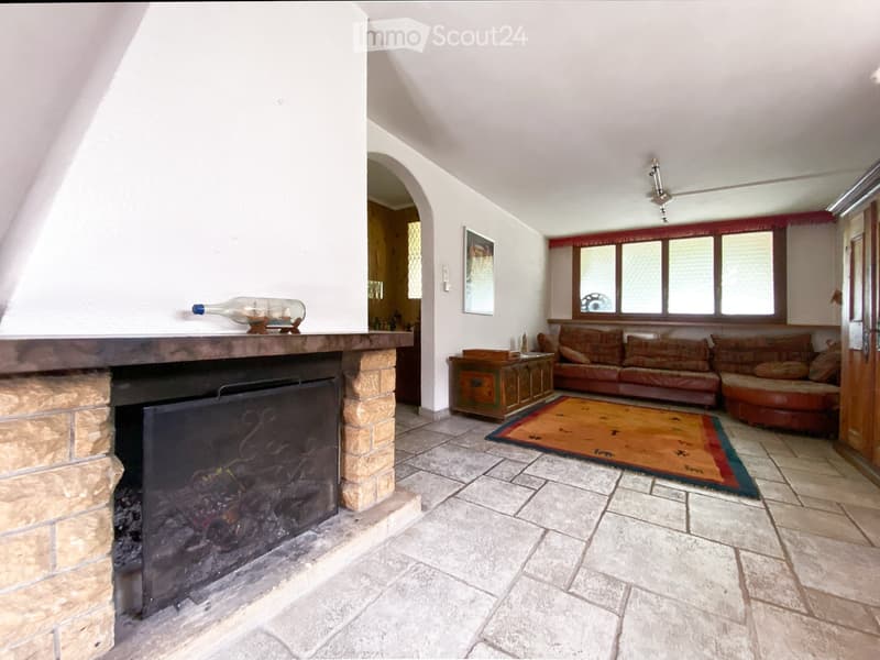 Fireplace, brown leather sofa, wooden coffee table, rug, wooden door