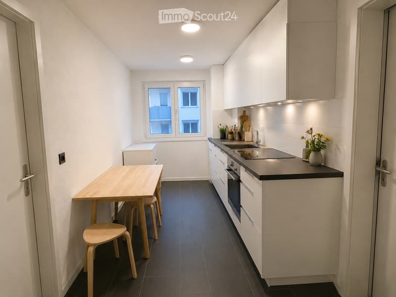 Modern kitchen with white cabinets, dark countertops, a wooden dining table with four stools, and a window overlooking a cityscape.