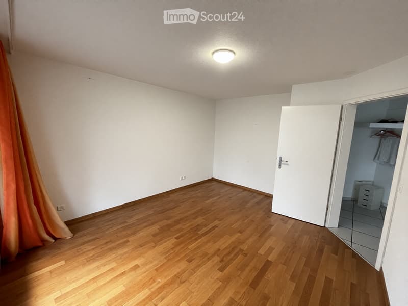 Empty room with wooden flooring, white walls, and a closed door leading to a small closet area.