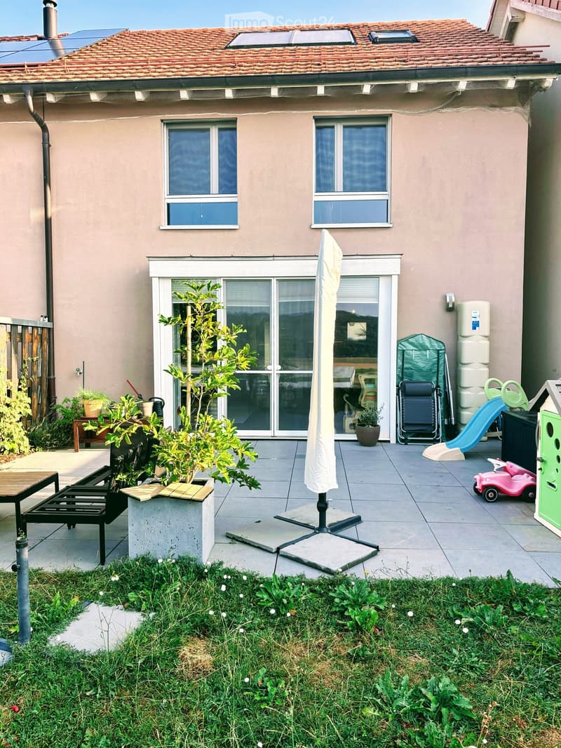 Garden area with patio, outdoor furniture, plants, slide, and small car toy.