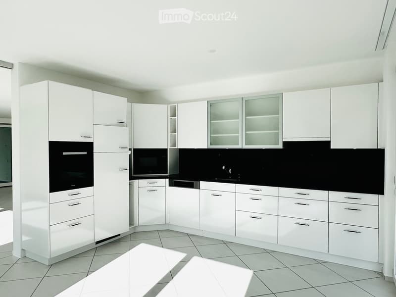 all white cabinets, black countertops, dishwasher, oven, refrigerator, tiled floor