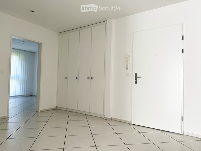 white tiled floor, white walls, white wardrobes, white door, window with blinds