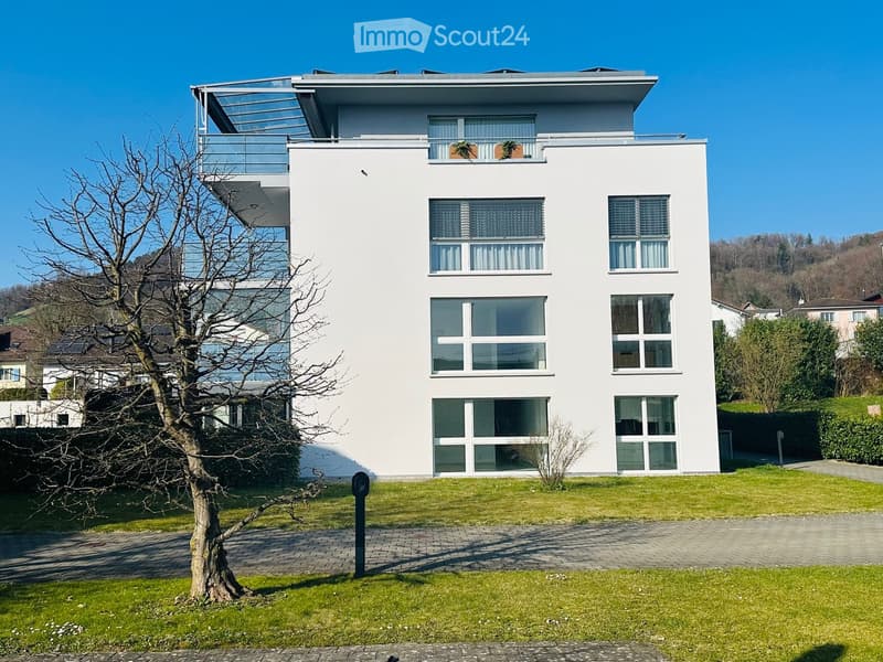 modern white house, 3 floors, large windows, balcony on the top floor, solar panels on the roof