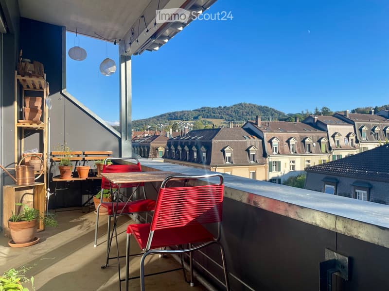 Balcony with a wooden table, red chairs, potted plants, and a view of the cityscape.