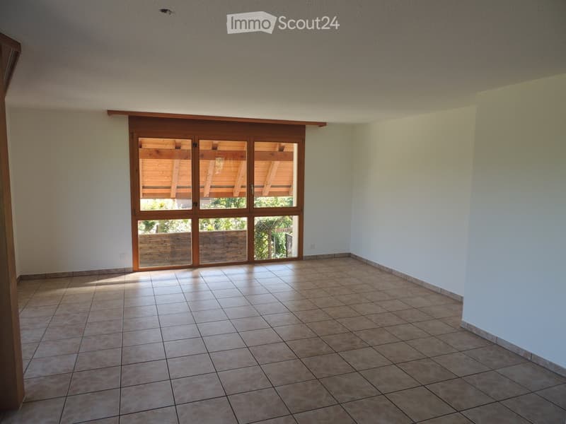 Empty room with tiled floor, white walls, and large sliding glass doors leading to an outdoor area.