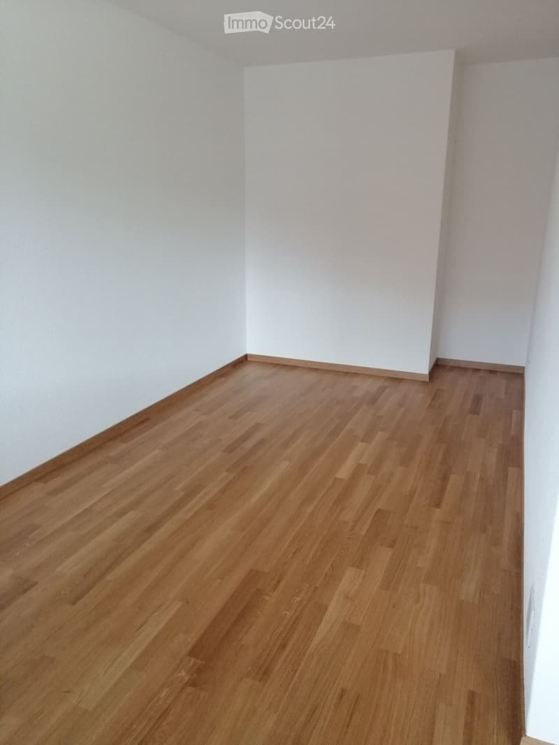 Empty room with light wooden flooring and white walls, no furniture or equipment present.