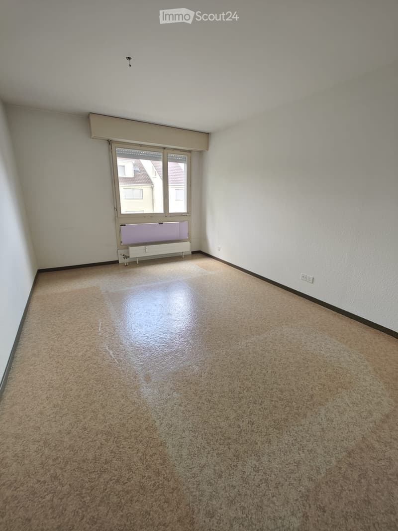 Empty room with beige carpet, white walls, and a large window with blinds. No furniture or equipment is present.
