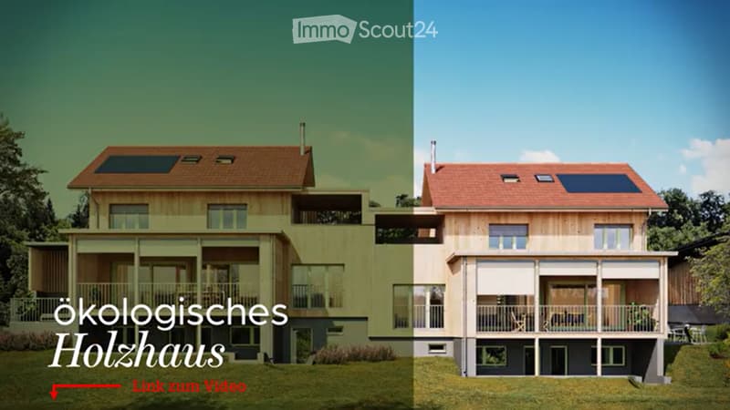 Two-story modern wooden house with large windows, solar panels on the roof, and a spacious balcony area.