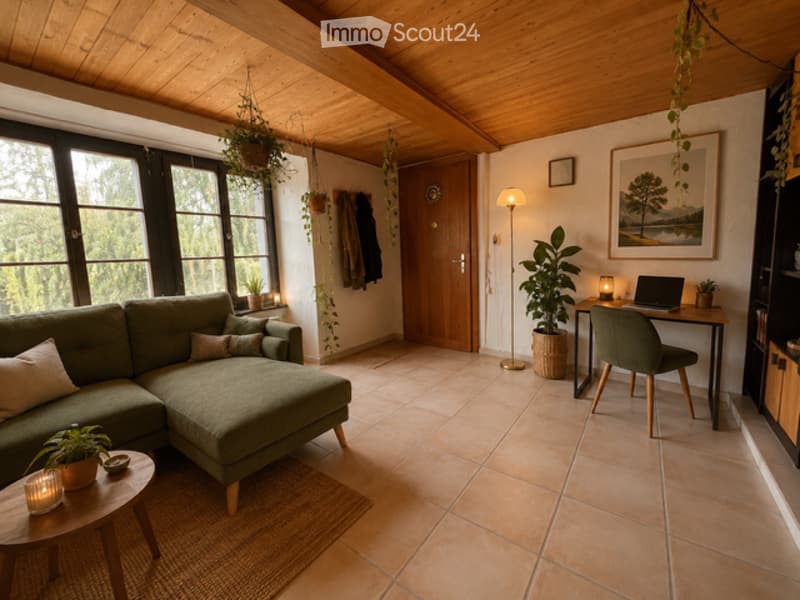 A cozy living room with a green sectional sofa, wooden coffee table, laptop on a desk, floor lamp, and several potted plants. The room features large windows with a view of greenery outside, a wooden door, and a warm, inviting atmosphere.