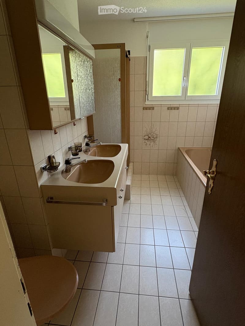 Bathroom with two sinks, bathtub, toilet, and tiled floor